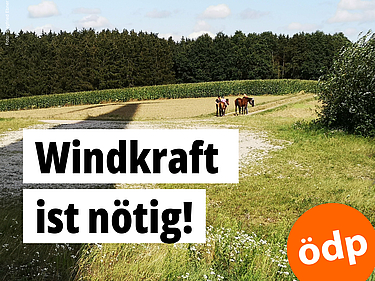 Ein Windrad wirft seinen Schatten auf eine Landschaft, in der zwei Kinder mit ihren Ponys spazieren gehen